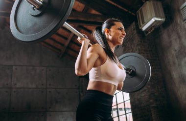 Güzel bir kadın antrenmanı ve spor salonunda egzersiz yapıyor.