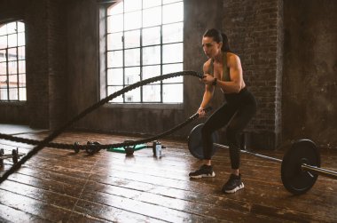 Güzel bir kadın antrenmanı ve spor salonunda egzersiz yapıyor.