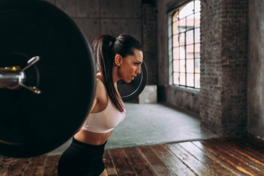 Güzel bir kadın antrenmanı ve spor salonunda egzersiz yapıyor.