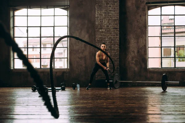 Güzel bir kadın antrenmanı ve spor salonunda egzersiz yapıyor.