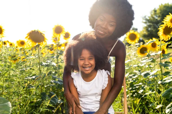 Vacker Afro Amerikansk Mamma Och Dotter Palyserande Och Kul Solrosor — Stockfoto