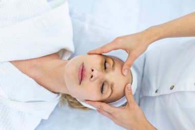 Güzellik merkezinde dinlenen güzel bir kadın müşterisi güzellik salonunda güzellik tedavisi görüyor.