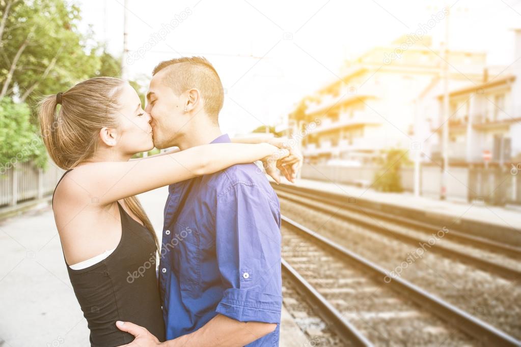 Couple hug each other at the train station