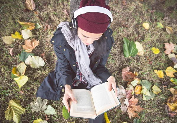 Girl reading book in a garden — Stock Photo, Image