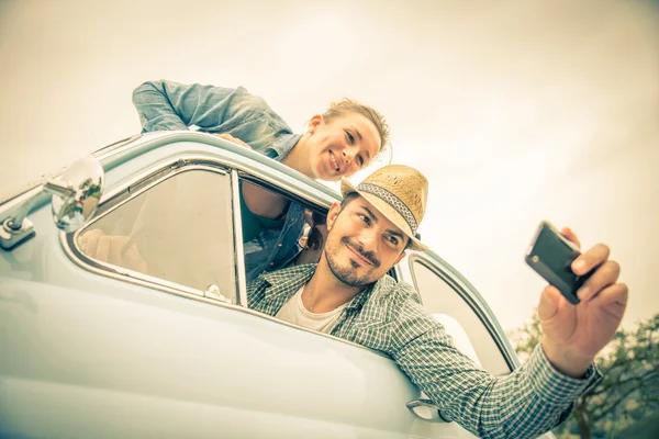 Pareja feliz viajando en un coche vintage — Foto de Stock