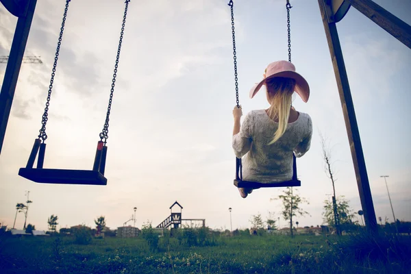 Woman playing on a swing at sunset — Stock Photo, Image