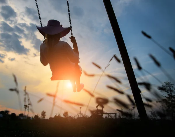 Žena hrající na houpačce při západu slunce — Stock fotografie
