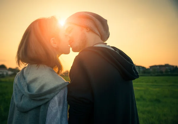 Çift kendilerini öpüşme gün batımında — Stok fotoğraf