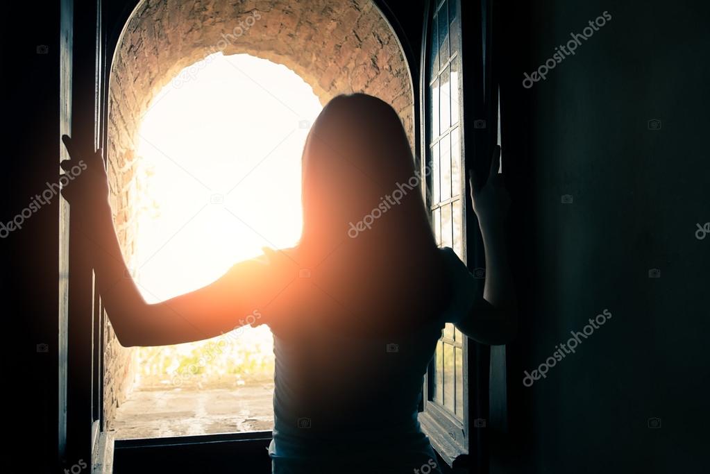 Woman opens windows and enjoys the landscape