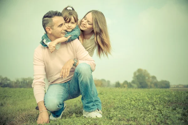 Famille heureuse jouant à l'extérieur — Photo