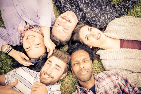 Группа друзей, лежащих на траве — стоковое фото