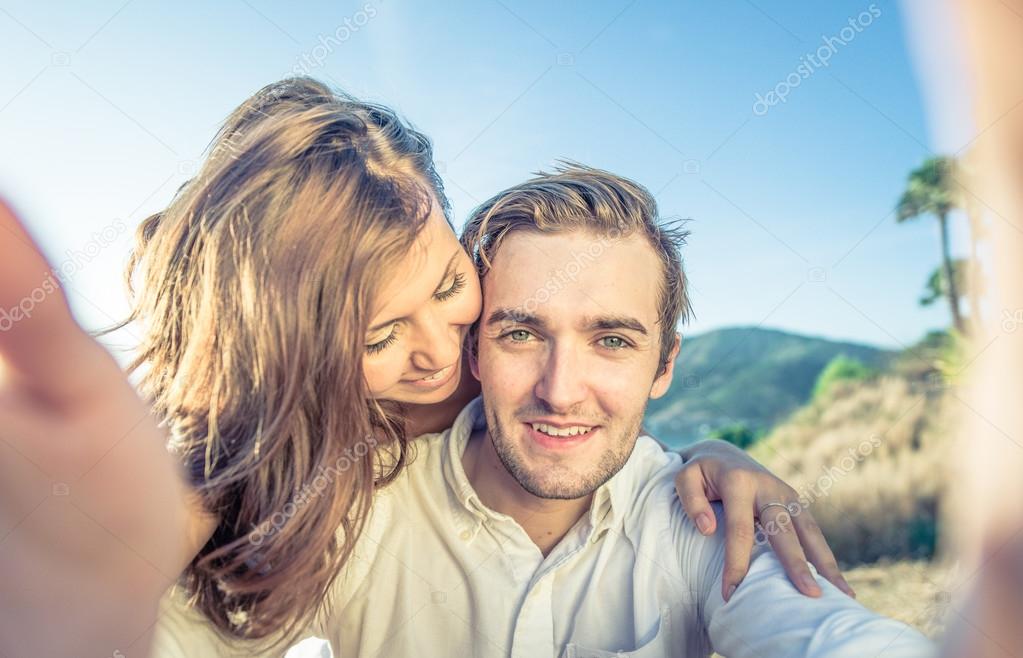 Happy couple in love pose for selfie in modern professional camera, have  walk outdoor, explore unknown places in big tourists city, model against  wonderful landscape with water in background 10373819 Stock Photo