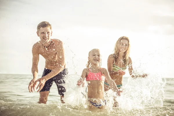Hravá rodina stříkající vody a baví — Stock fotografie