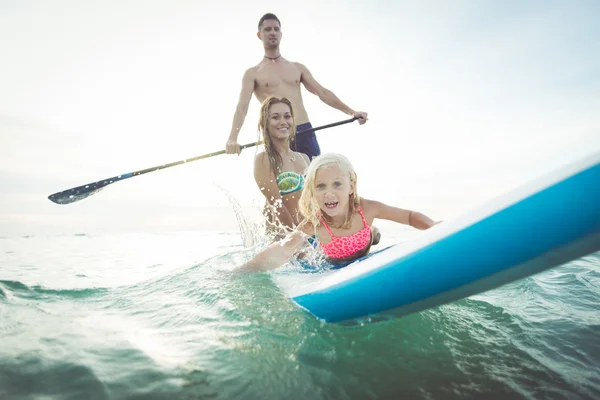 Familia haciendo paddle surf en el océano — Foto de Stock