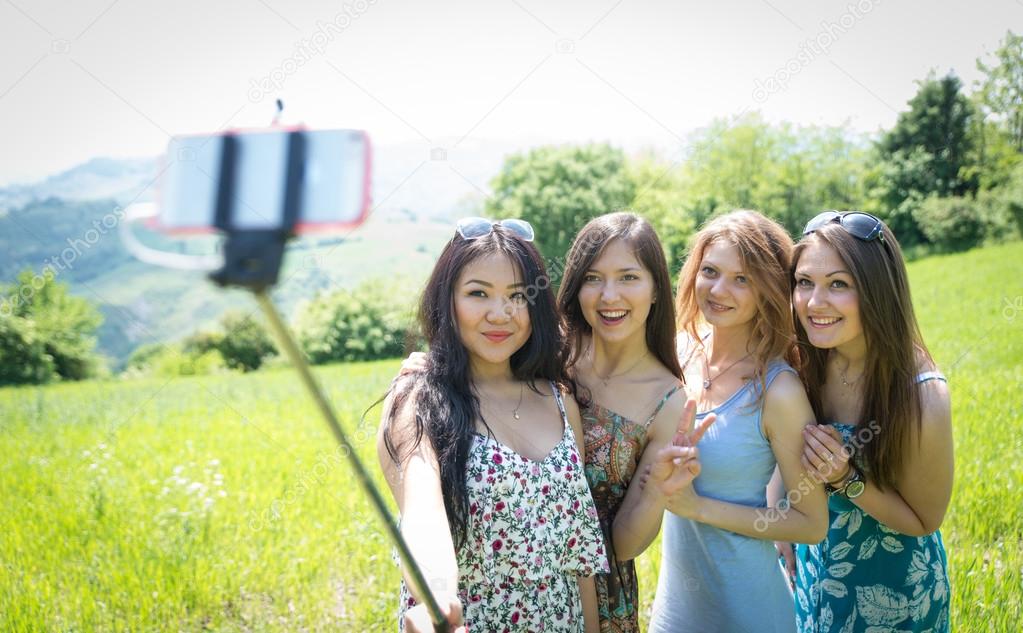 group of girls making selfie with selfie stick