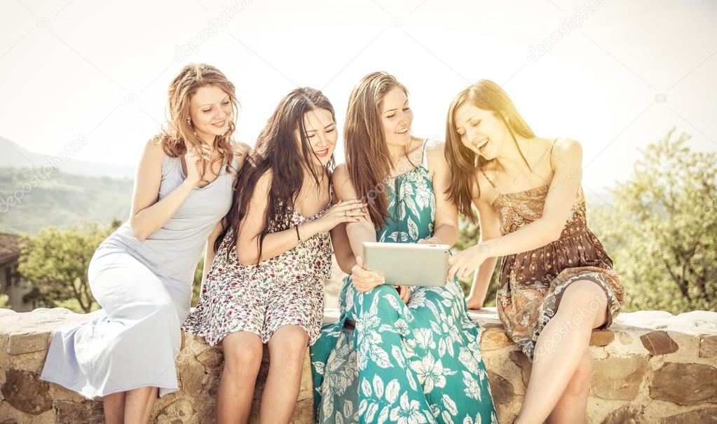 group of girls watching tablet outdoor