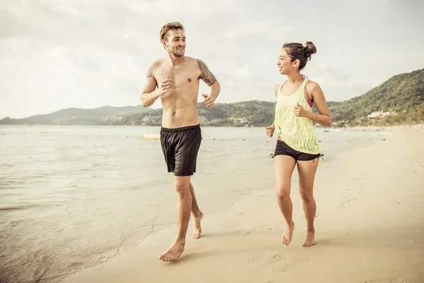 Casal misto corrida na praia — Fotografia de Stock