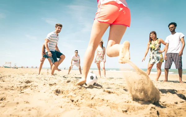 Группа друзей играют в футбол на пляже — стоковое фото