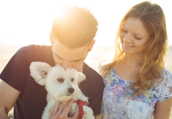 Jovem casal e cão branco felizes juntos — Fotografia de Stock