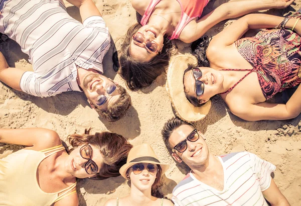 Grupo de amigos acostados en la playa — Foto de Stock