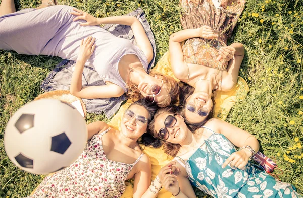 Vier Freunde liegen im Gras — Stockfoto