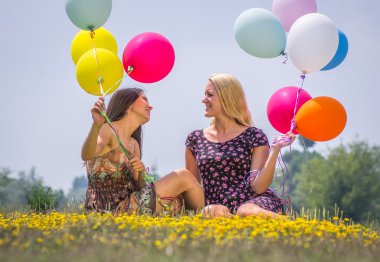 iki genç kız hava balonu ile çim yalan