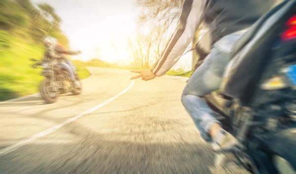 Two bikers greeting eachother on the way. concept about transportation — Stock Photo, Image