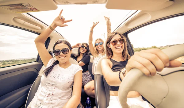 Four girls driving in a convertible car and having fun — Stock Photo, Image