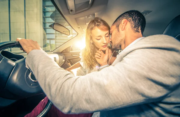 Pareja joven besándose con pasión dentro de un coche deportivo — Foto de Stock