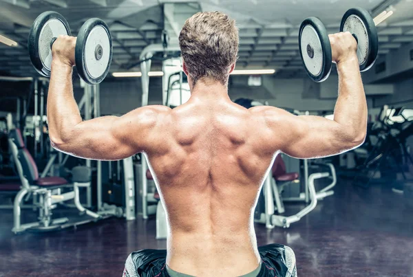 Culturista haciendo entrenamiento de entrenamiento. levantando las ruedas. concepto de gimnasio, deporte y personas —  Fotos de Stock