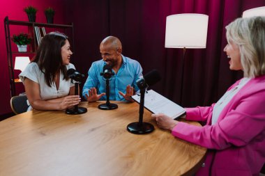 Üç farklı birey, bir ev sahibi ve birkaç konuk, bir ses podcast 'i kaydederken gülümsüyor ve sohbete dalıyorlar ya da profesyonel bir stüdyoda mikrofonla canlı yayın yapıyorlar.