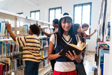 Kütüphanede buluşan çok ırklı bir grup genç öğrenci. Elinde bir kitapla kameraya gülümseyen genç bir kız öğrenci. Diğer etnik çeşitlilikteki öğrenciler ise kütüphane raflarını karıştırıyor.