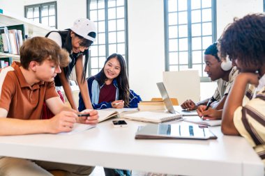 Kütüphanede buluşan çok ırklı bir grup genç öğrenci. Modern bir kütüphanede üniversite projesinde işbirliği yapan, fikirleri paylaşan ve teknolojiyi kullanan bir grup genç öğrenci.