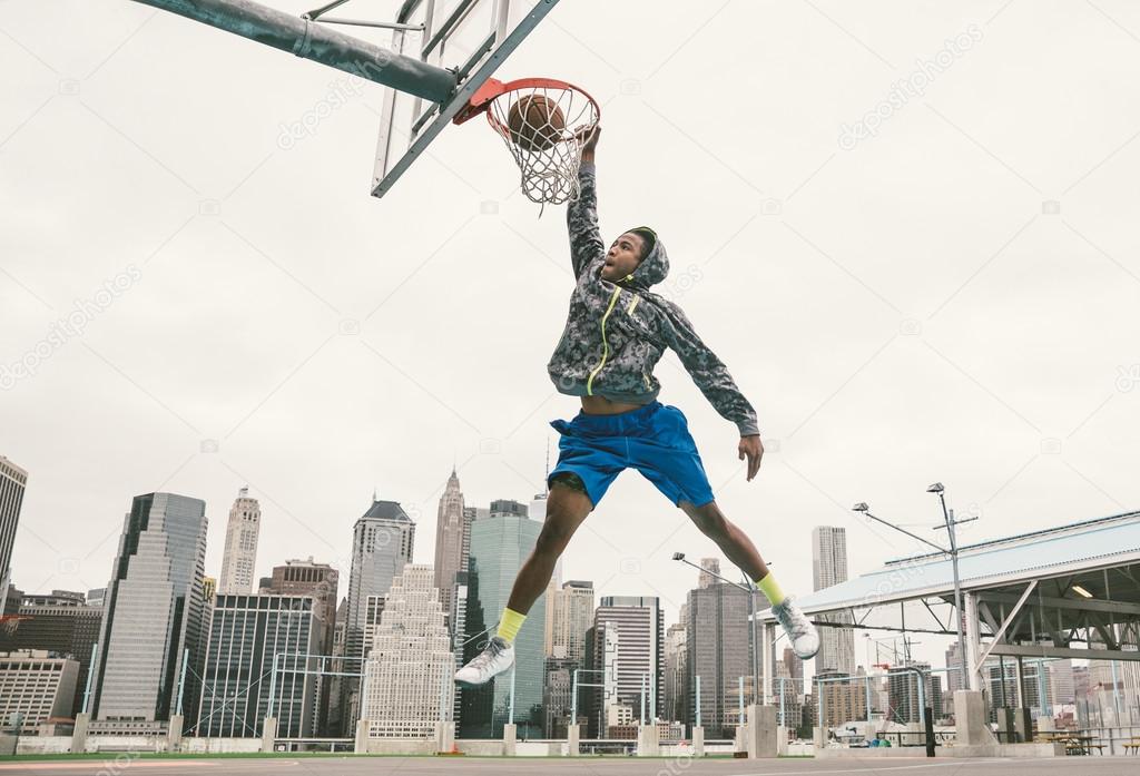 basketball player performing slum dunk