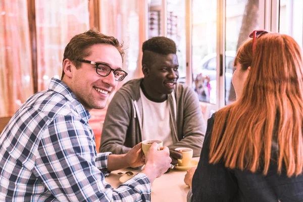 Multiracial group of friend in a coffee bar — Stock Photo, Image