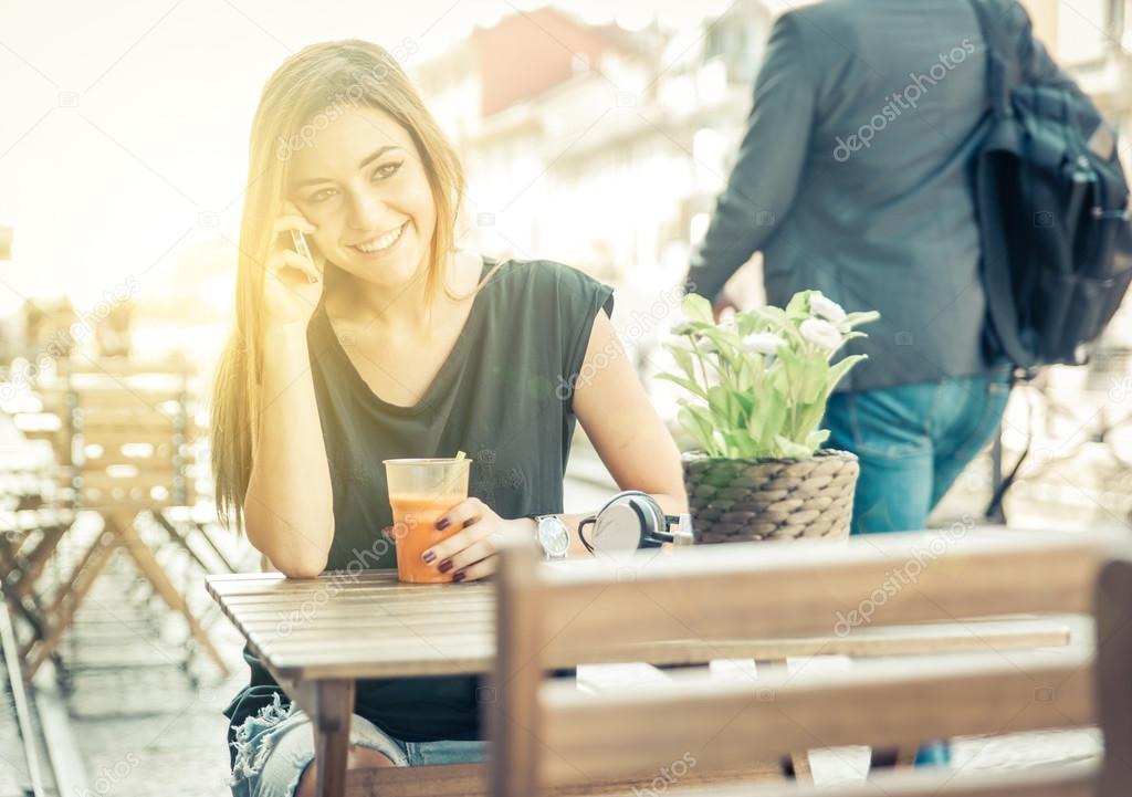 Woman talking on the phone while sitting in a bar