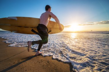 Surfer running into the ocean