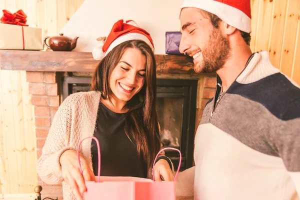 Jeune couple partageant des cadeaux de Noël — Photo