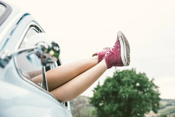Kadın bacaklar dışında eski model bir araba — Stok fotoğraf