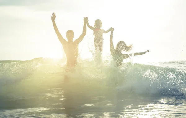 Glückliche Familiensilhouette im Wasser — Stockfoto