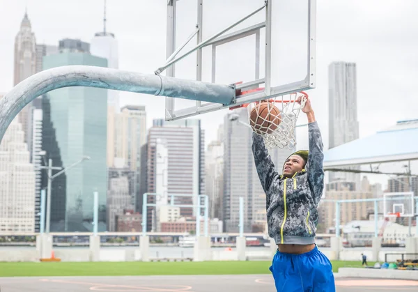 Jogador de basquete fazendo um slam dunk — Fotografia de Stock