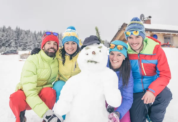 Groep vrienden maakte een sneeuwpop — Stockfoto