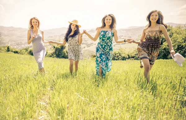 Group of girls running in a field Stock Photo
