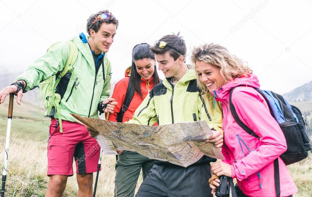 Group of hikers watching the map on the mountains