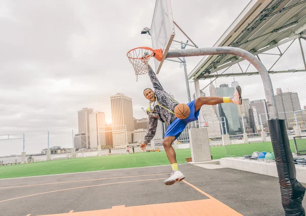 Sportive man hanging from the basket — Stock Photo, Image