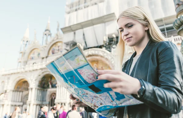 Blond meisje controle van de kaart in Venetië San Marco plein — Stockfoto