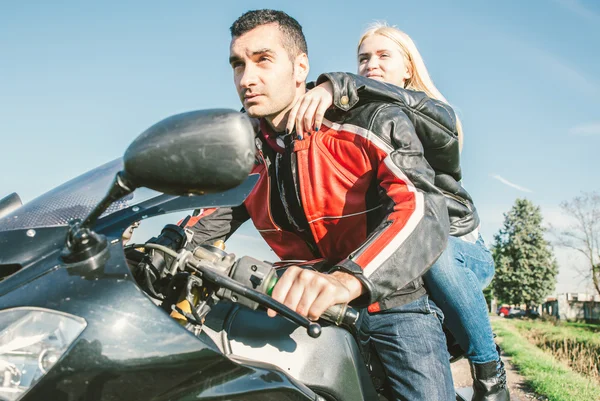 Молодая пара за рулем спортивного мотоцикла — стоковое фото