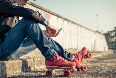 Genç kaykaycı çocuk akıllı telefon ile