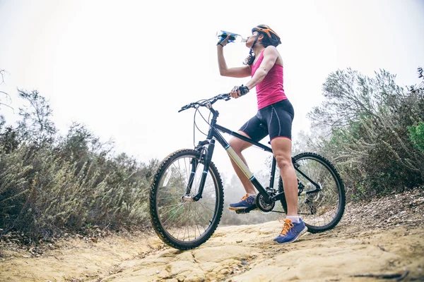Γυναίκα πόσιμο νερό σε ένα ποδήλατο — Φωτογραφία Αρχείου