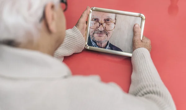 Vecchia donna guardando la foto di suo marito — Foto Stock